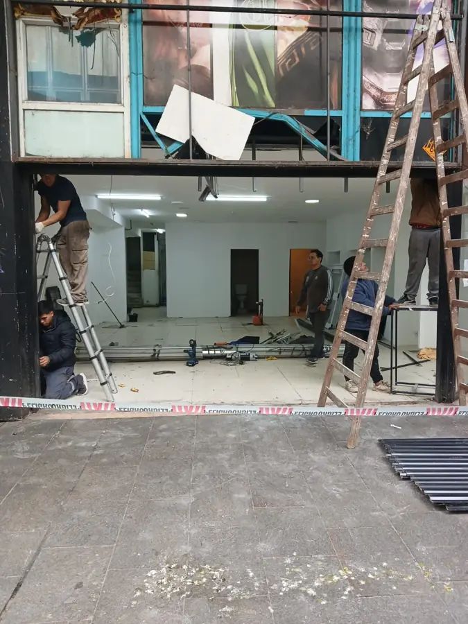 Equipo instalando una cortina metálica en un local comercial